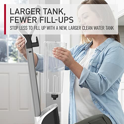 Woman attaching larger clean water tank to cleaning device, making it easier to clean and less time spent on fill-ups.